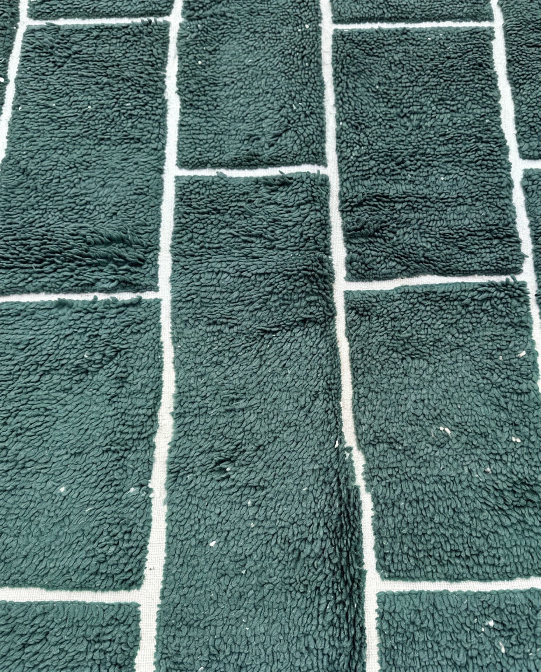 FIDA Beni Ourain forest green checker grid Moroccan rug close-up showing hand-knotted wool texture and pile detail, by NURA