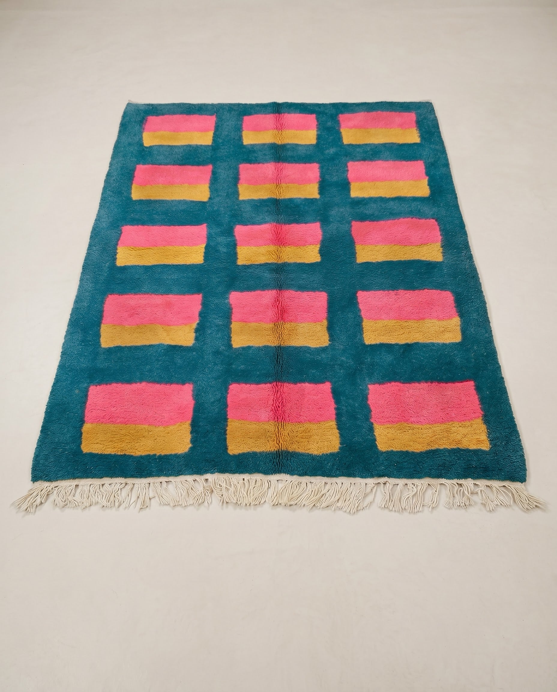 GHALIA Mrirt teal color block grid Moroccan rug displayed on a parquet wood floor, showing full fringe and edge detail, by NURA