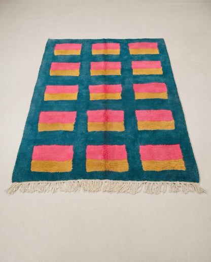 GHALIA Mrirt teal color block grid Moroccan rug displayed on a parquet wood floor, showing full fringe and edge detail, by NURA