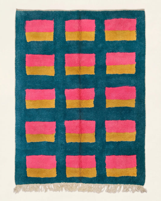 A vibrant Moroccan wool rug featuring a deep teal background with a geometric grid of hot pink and mustard yellow color blocks.