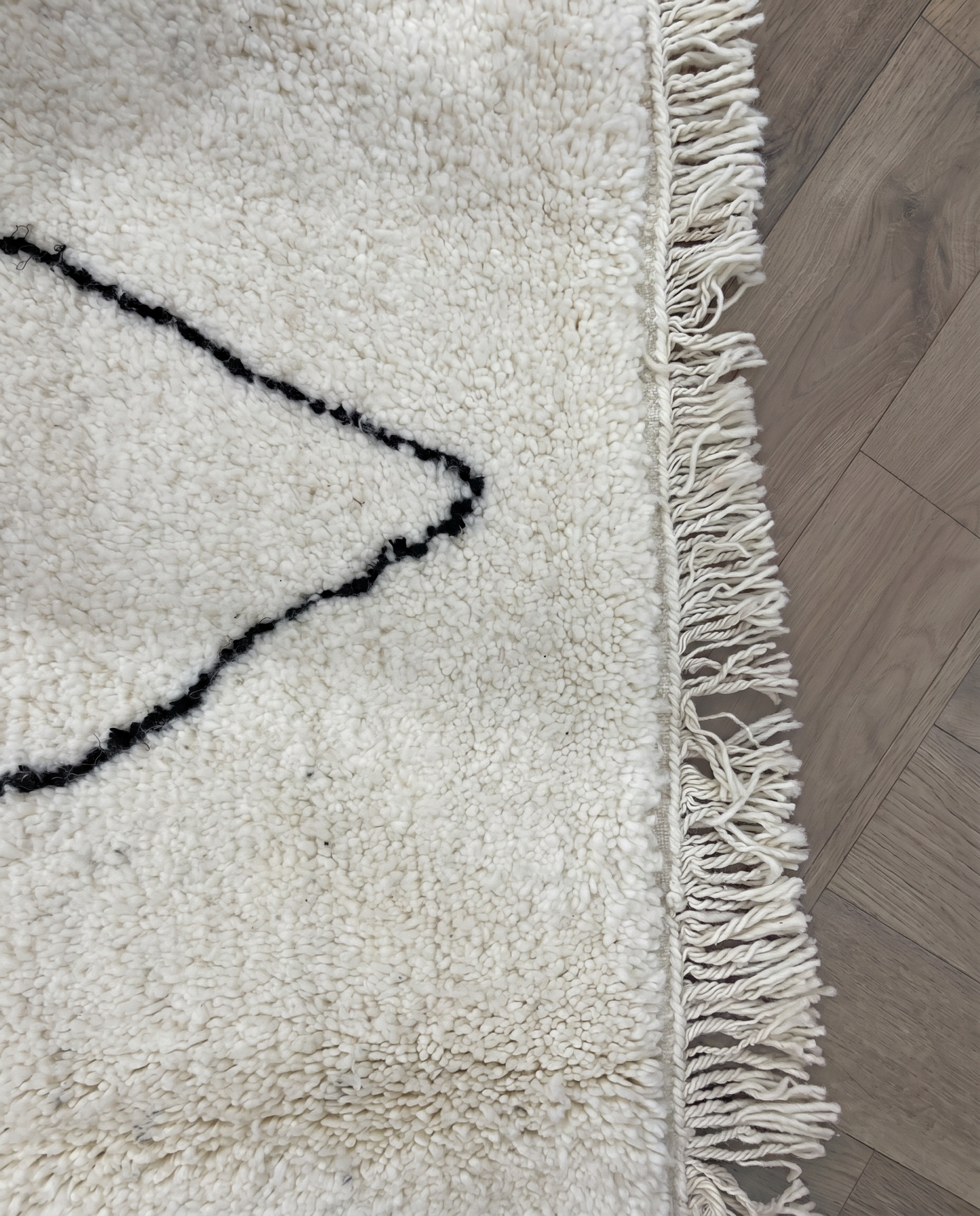 GHITA Beni Ourain ivory diamond lattice Moroccan rug close-up of hand-tied fringe and kilim band detail, by NURA
