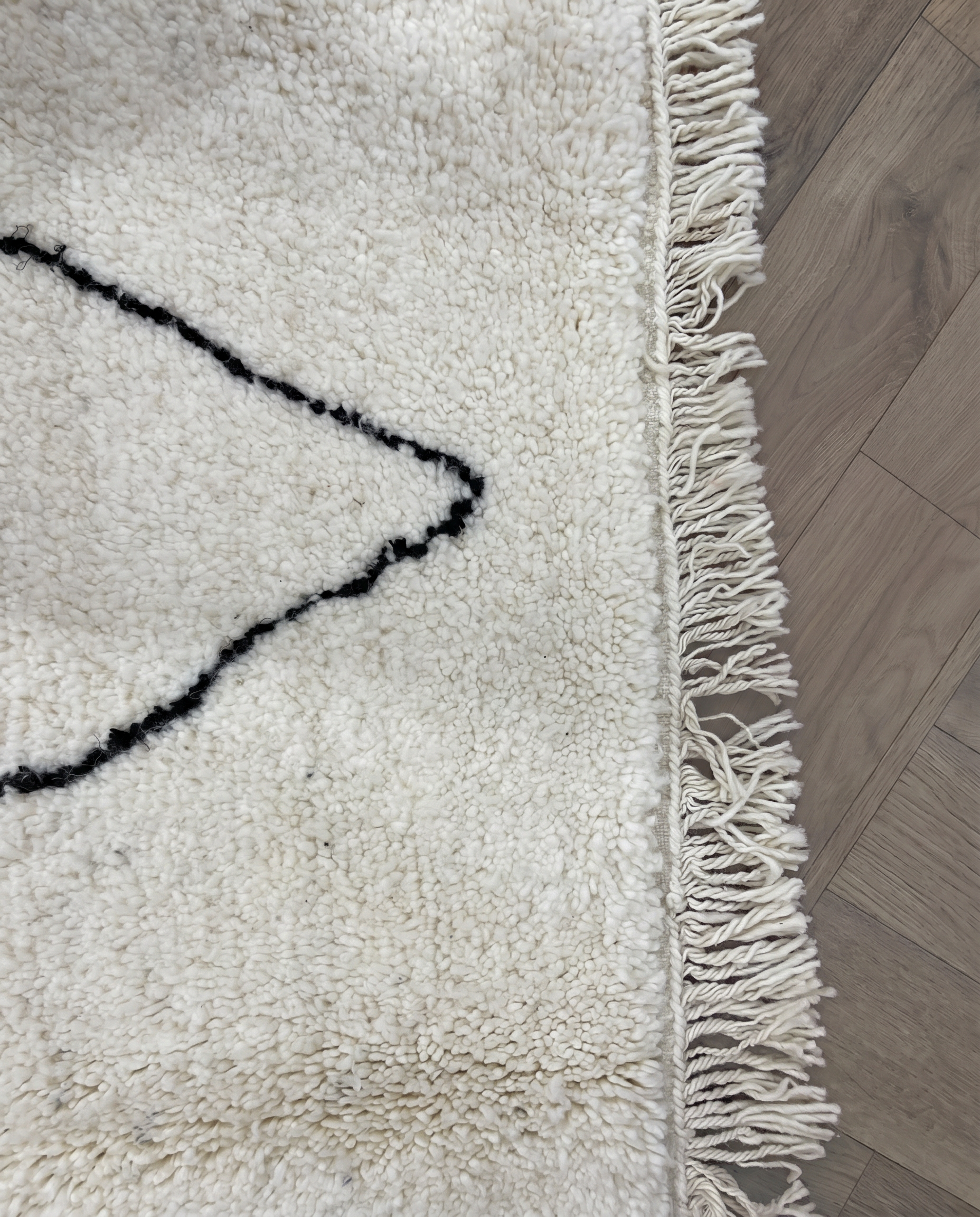 GHITA Beni Ourain ivory diamond lattice Moroccan rug close-up of hand-tied fringe and kilim band detail, by NURA