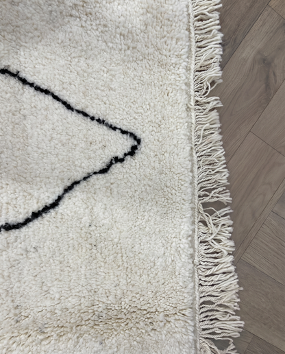 GHITA Beni Ourain ivory diamond lattice Moroccan rug close-up of hand-tied fringe and kilim band detail, by NURA