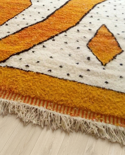 HIBA Mrirt cream bold abstract field Moroccan rug close-up of hand-tied fringe and kilim band detail, by NURA