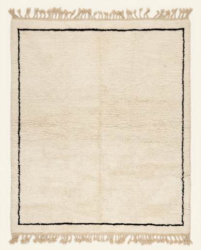 Plush ivory Beni Ourain Moroccan rug with a minimal black border and a thick natural wool high pile, by NURA.