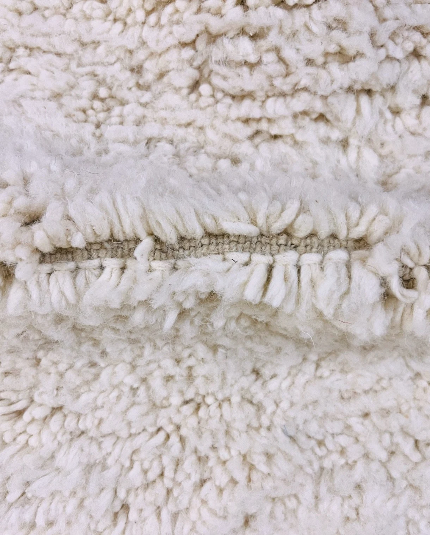 IKRAM Beni Ourain ivory solid border Moroccan rug close-up showing hand-knotted wool texture and pile detail 3, by NURA