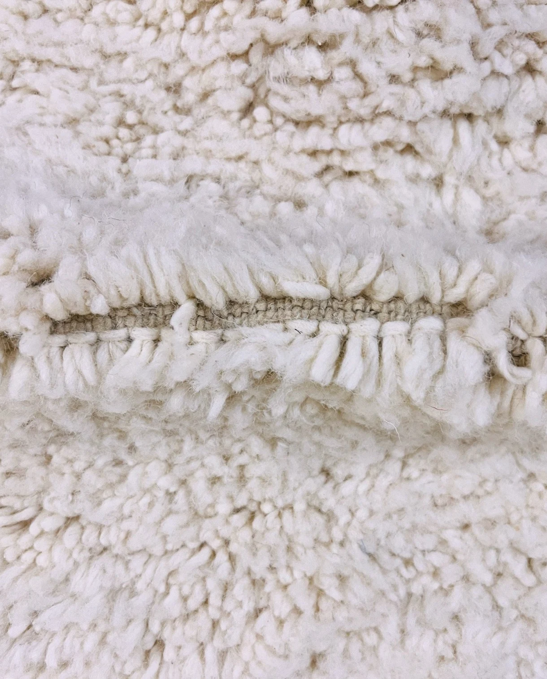 IKRAM Beni Ourain ivory solid border Moroccan rug close-up showing hand-knotted wool texture and pile detail 3, by NURA