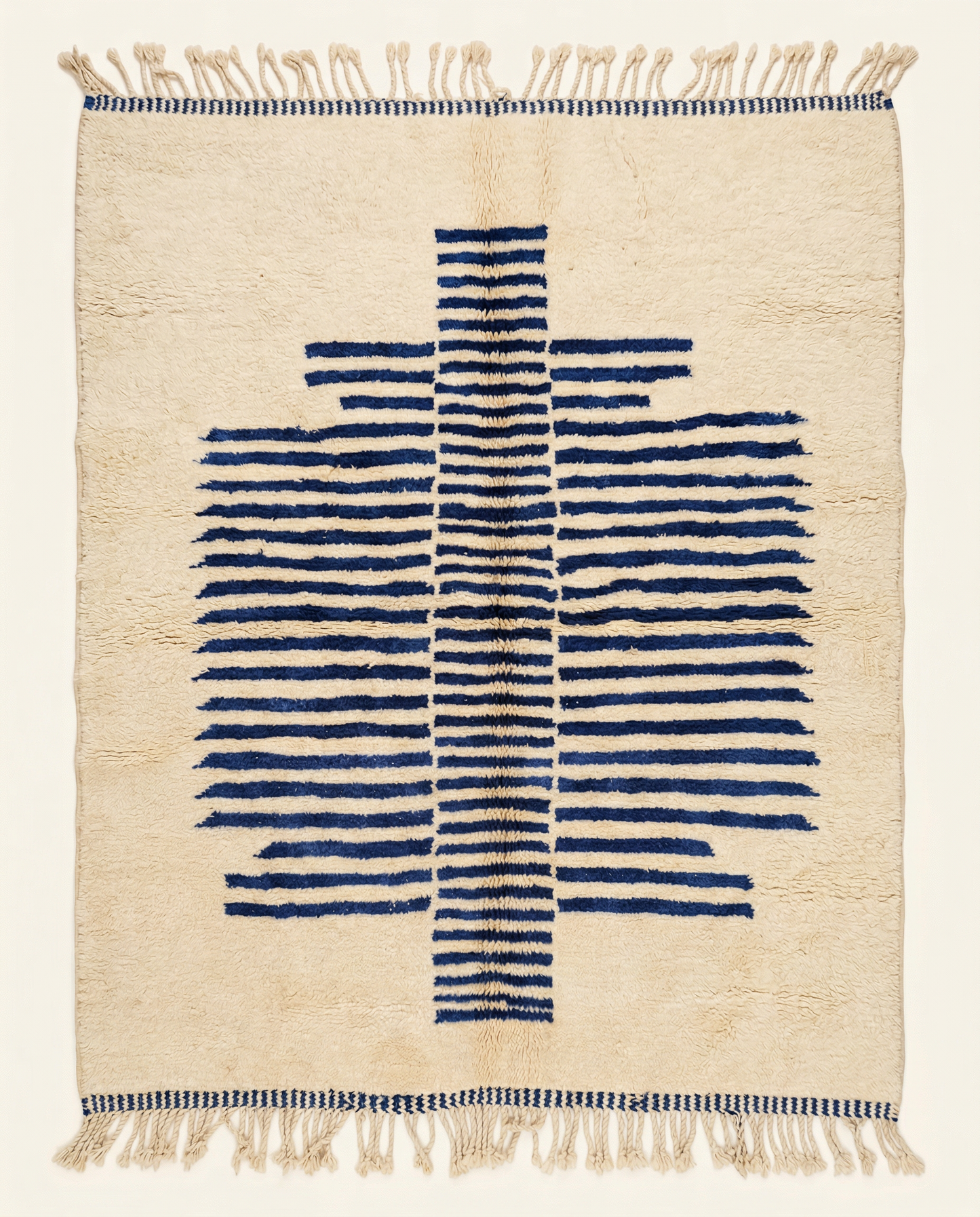 Plush cream Beni Ourain Moroccan rug with a bold cobalt blue striped central medallion and high pile, by NURA.