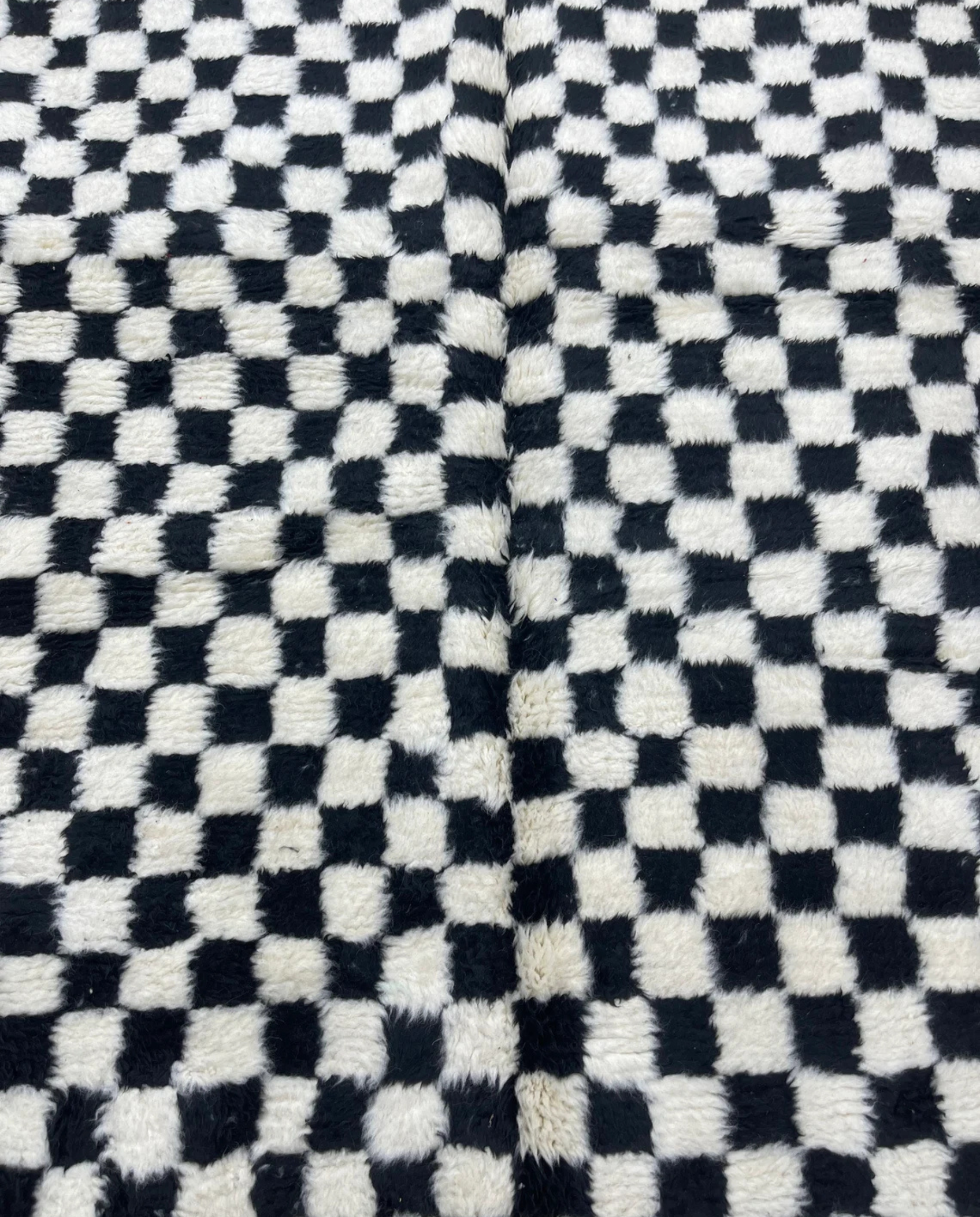 JAMILA Beni Ourain black checker grid Moroccan rug close-up showing hand-knotted wool texture and pile detail, by NURA