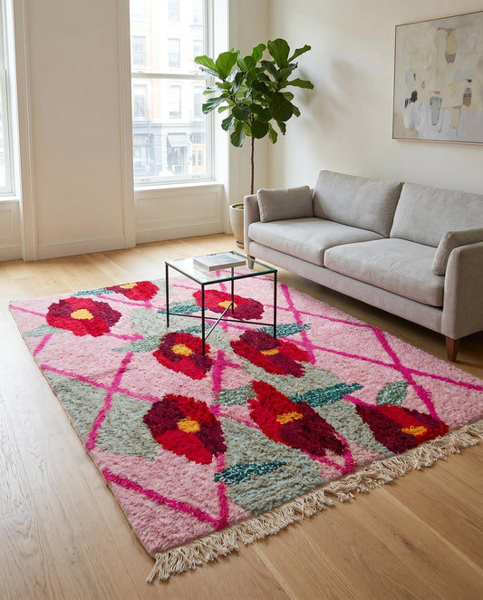 A plush pink Moroccan floral rug by NURA anchors a bright living room, adding a bold pop of color and cozy texture.