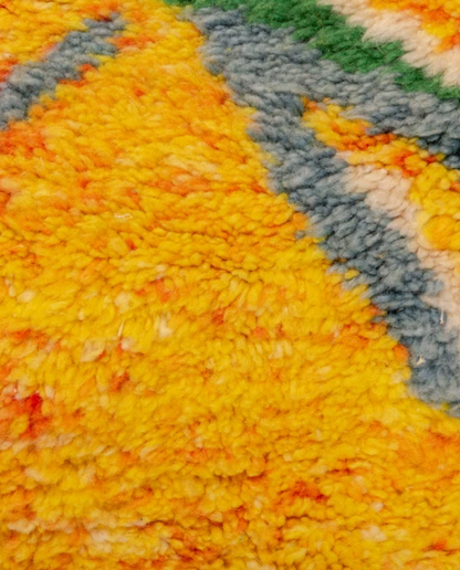 KAMILA Azilal saffron abstract branch motif Moroccan rug close-up showing hand-knotted wool texture and pile detail, by NURA
