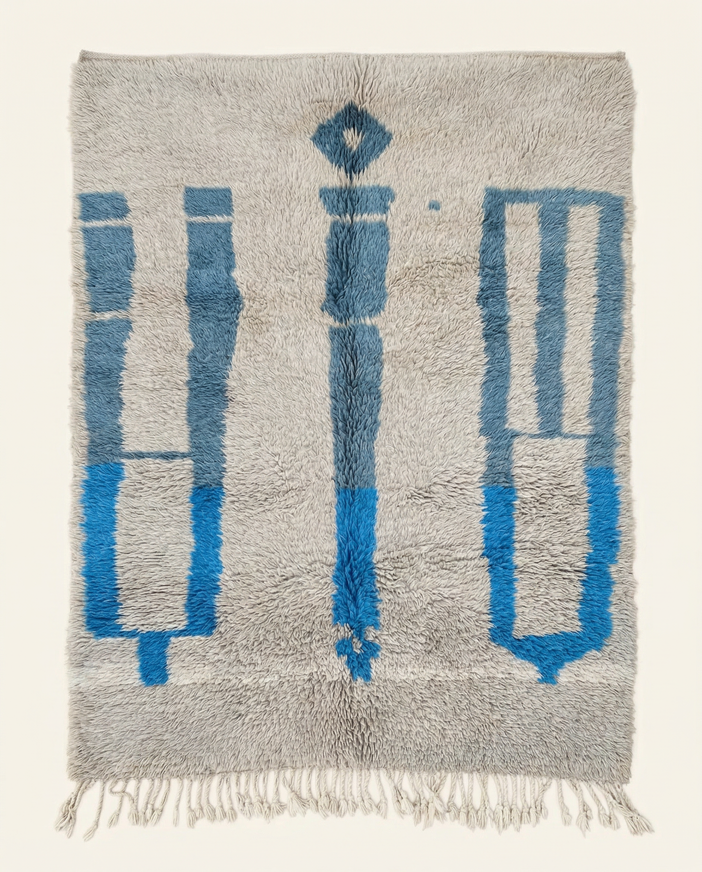 Plush silver-grey Beni Ourain Moroccan rug with bold cobalt blue abstract motifs and a thick high pile, by NURA.