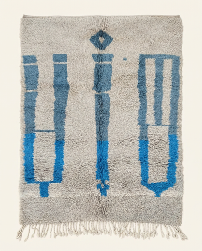 Plush silver-grey Beni Ourain Moroccan rug with bold cobalt blue abstract motifs and a thick high pile, by NURA.