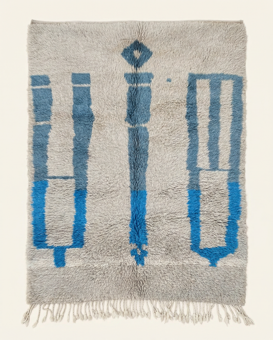 Plush silver-grey Beni Ourain Moroccan rug with bold cobalt blue abstract motifs and a thick high pile, by NURA.