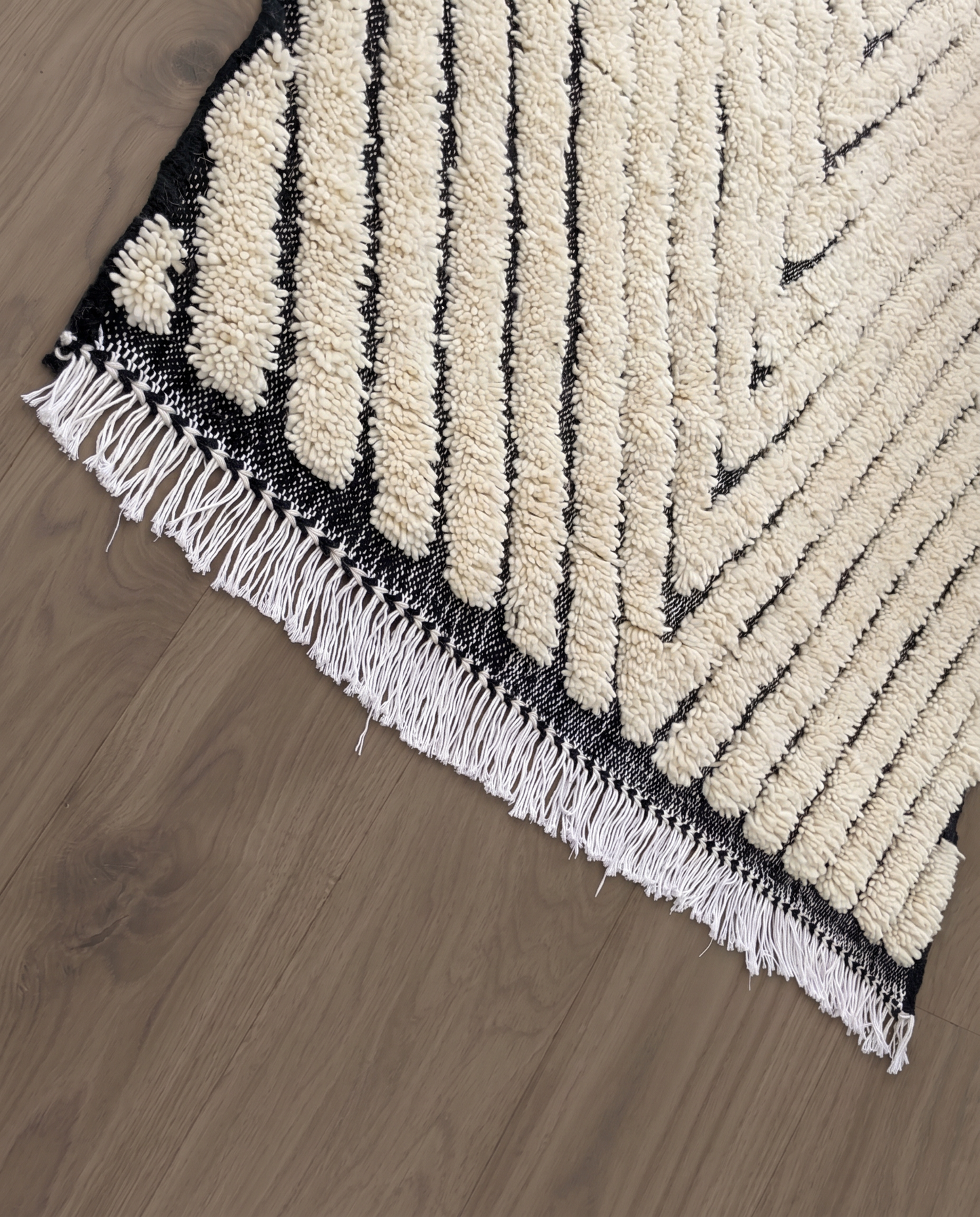 KARMA Azilal cream chevron lines Moroccan rug close-up of hand-tied fringe and kilim band detail, by NURA