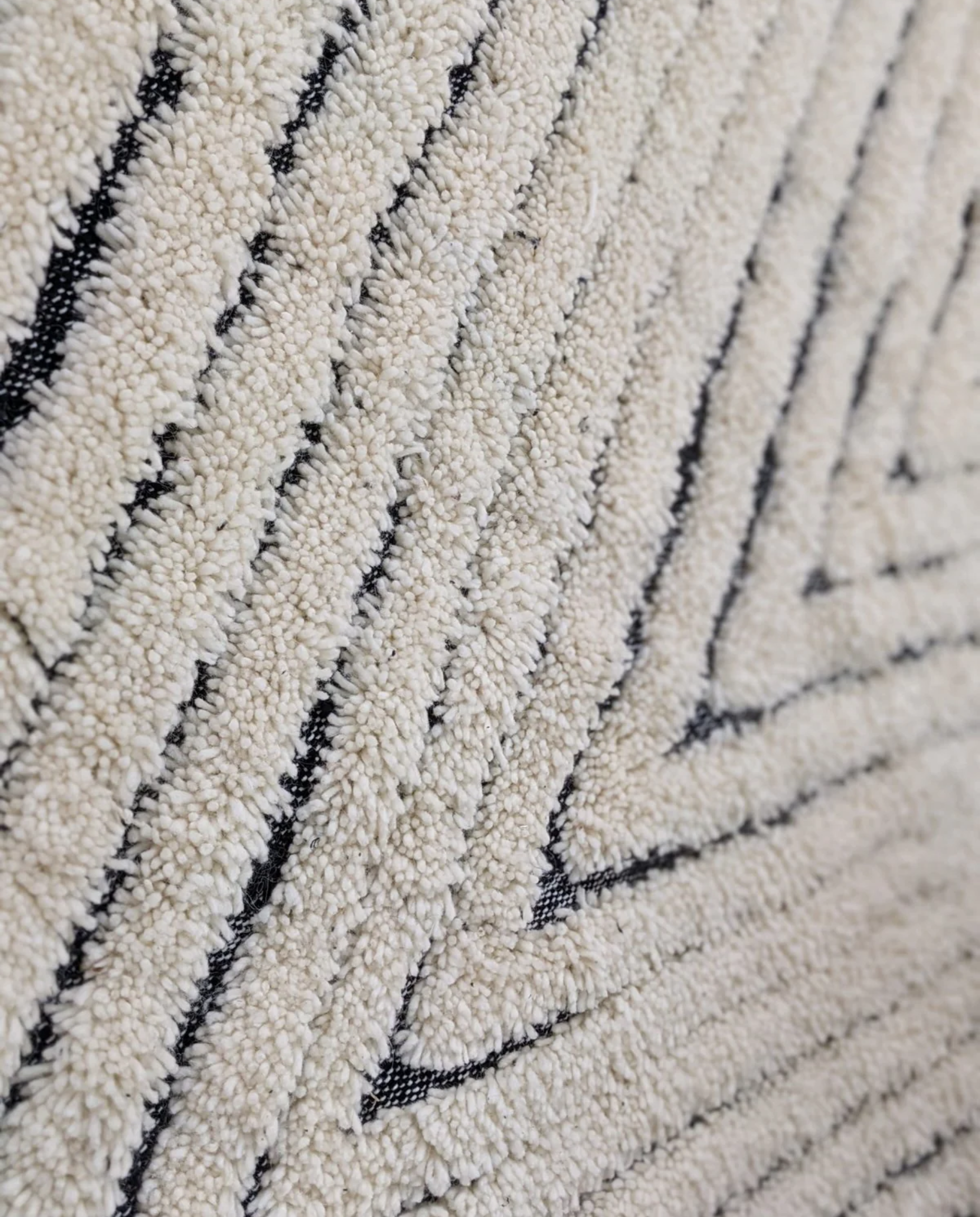 KARMA Azilal cream chevron lines Moroccan rug close-up showing hand-knotted wool texture and pile detail, by NURA