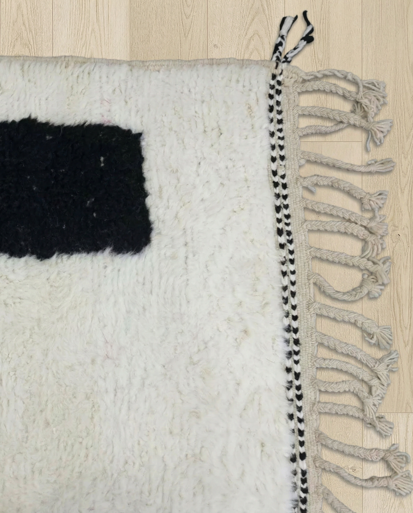 KENZA Azilal black abstract color block Moroccan rug close-up of hand-tied fringe and kilim band detail, by NURA