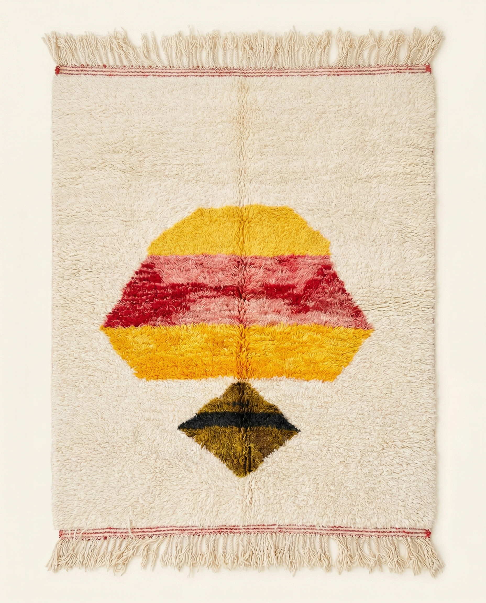 Plush ivory Azilal Moroccan rug with a bold central abstract motif in yellow, pink, and red, by NURA.