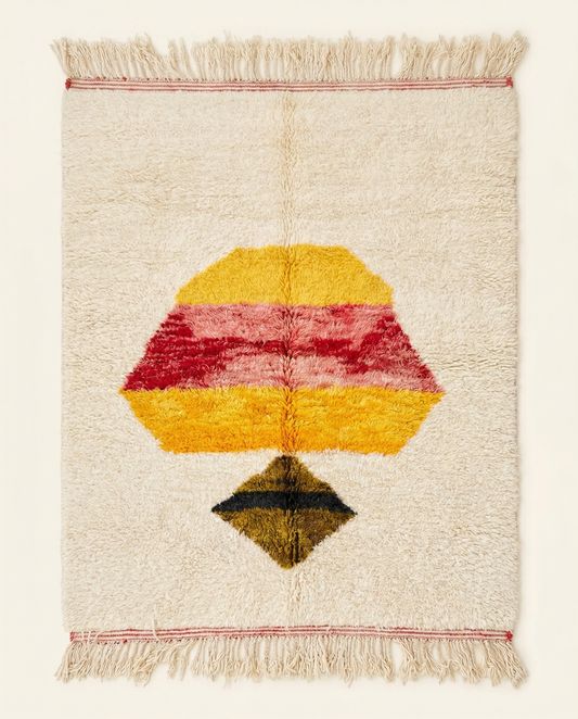 Plush ivory Azilal Moroccan rug with a bold central abstract motif in yellow, pink, and red, by NURA.