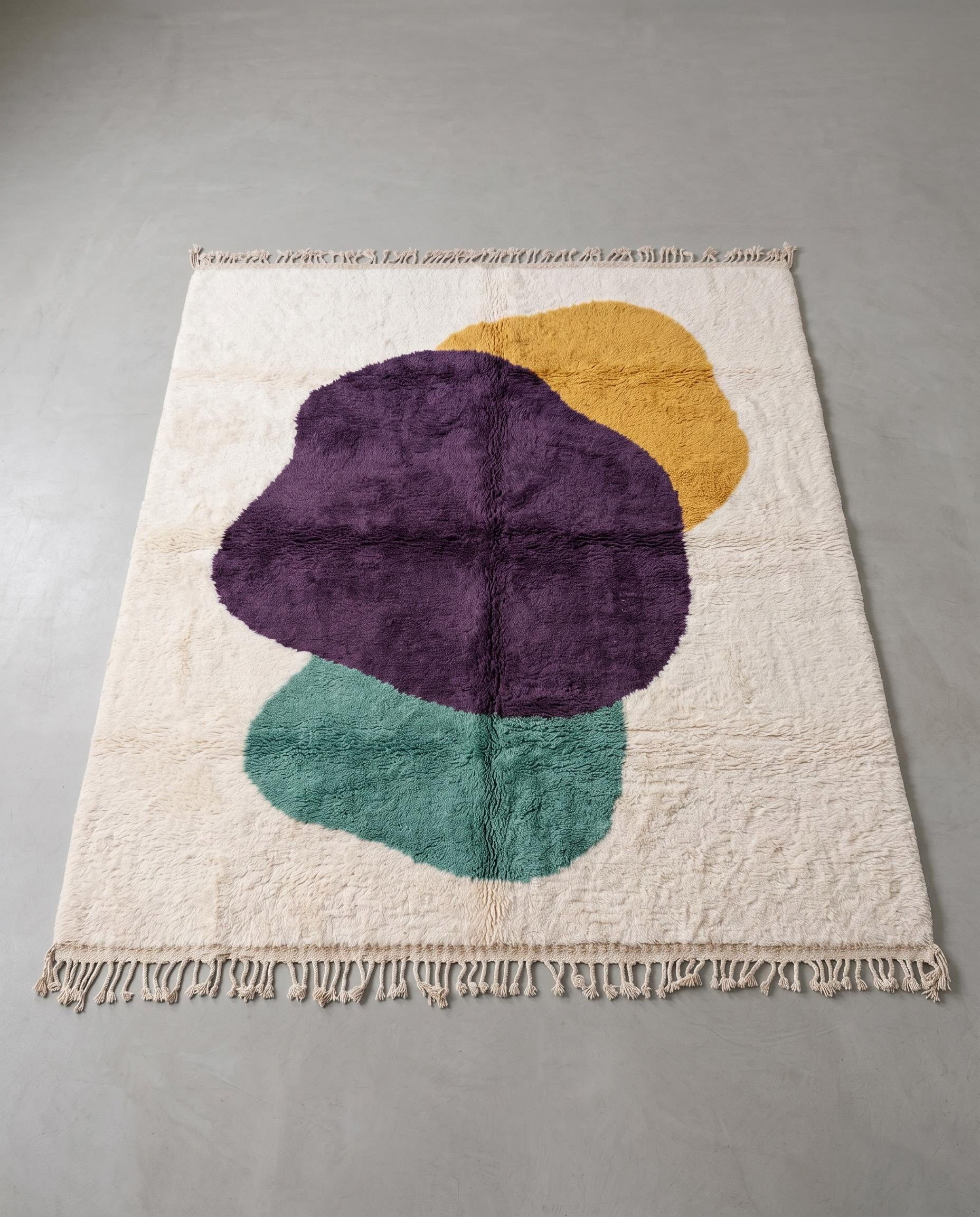 LAMA Azilal cream organic abstract Moroccan rug displayed on a parquet wood floor, showing full fringe and edge detail, by NURA