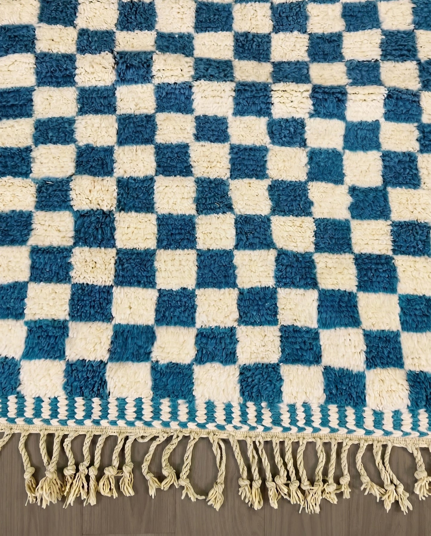 MAJDA Beni Ourain blue checker grid Moroccan rug close-up of hand-tied fringe and kilim band detail, by NURA