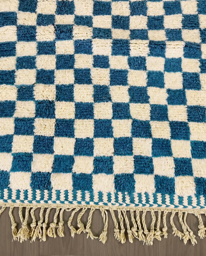 MAJDA Beni Ourain blue checker grid Moroccan rug close-up of hand-tied fringe and kilim band detail, by NURA