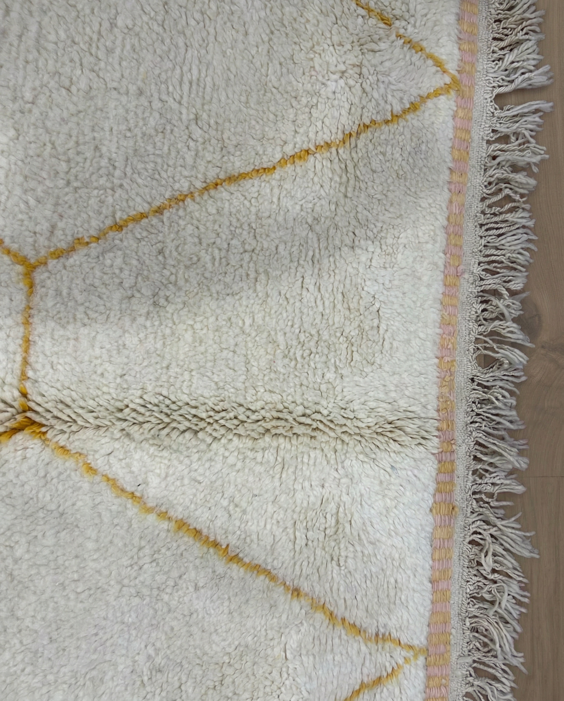 MALAK Beni Ourain cream abstract color block Moroccan rug close-up of hand-tied fringe and kilim band detail, by NURA