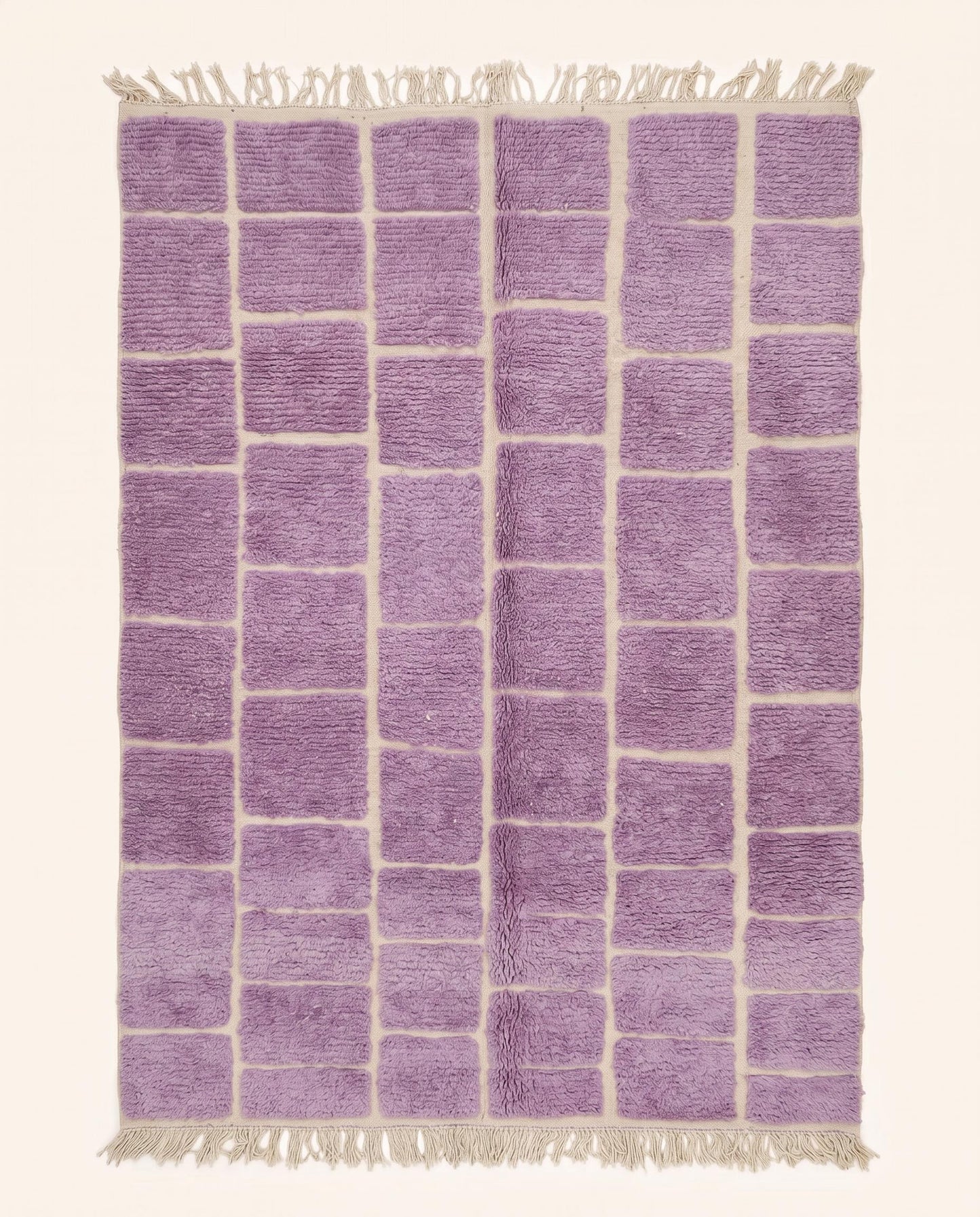A plush purple Moroccan rug featuring a modern cream checker grid pattern, hand-knotted from soft wool by NURA.