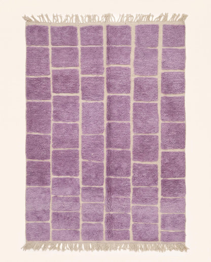 A plush purple Moroccan rug featuring a modern cream checker grid pattern, hand-knotted from soft wool by NURA.