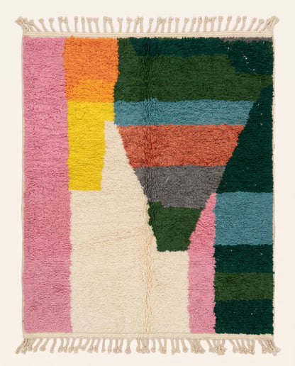 A vibrant Moroccan rug featuring a modern color block pattern in pink, green, blue, and orange wool pile, crafted by NURA.