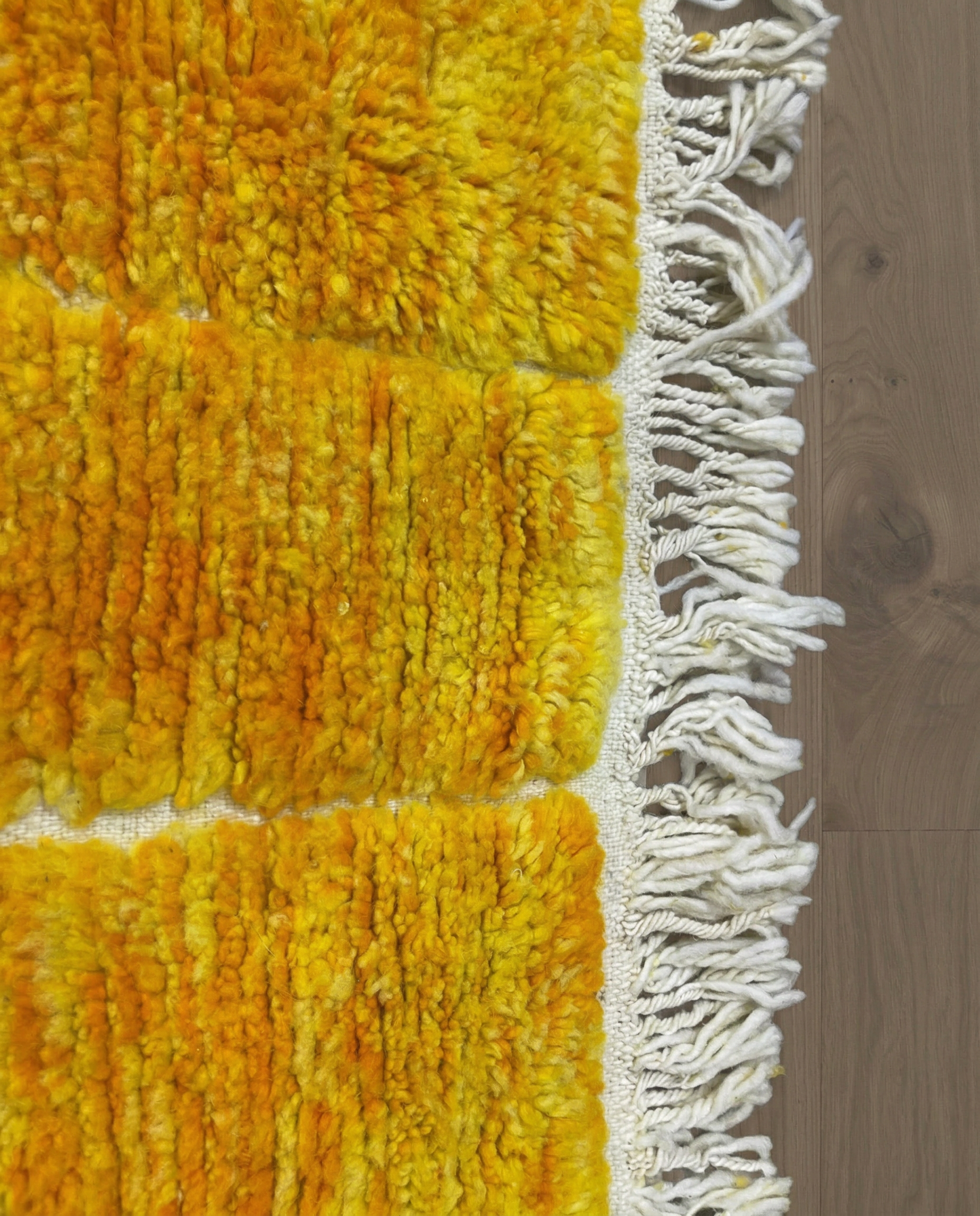 MIRA Beni Ourain saffron raised block grid Moroccan rug close-up of hand-tied fringe and kilim band detail, by NURA