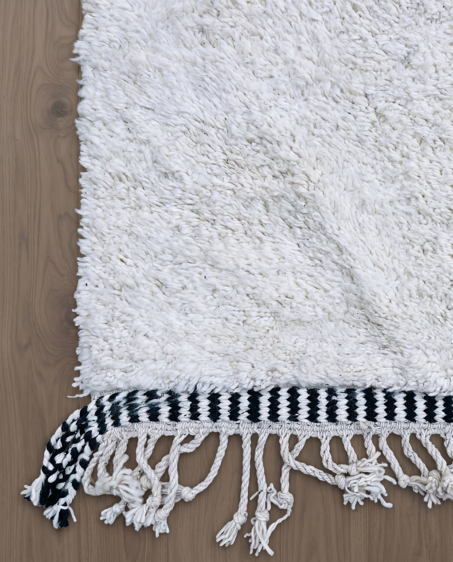 MOUNIA Beni Ourain ivory abstract color block Moroccan rug close-up of hand-tied fringe and kilim band detail, by NURA