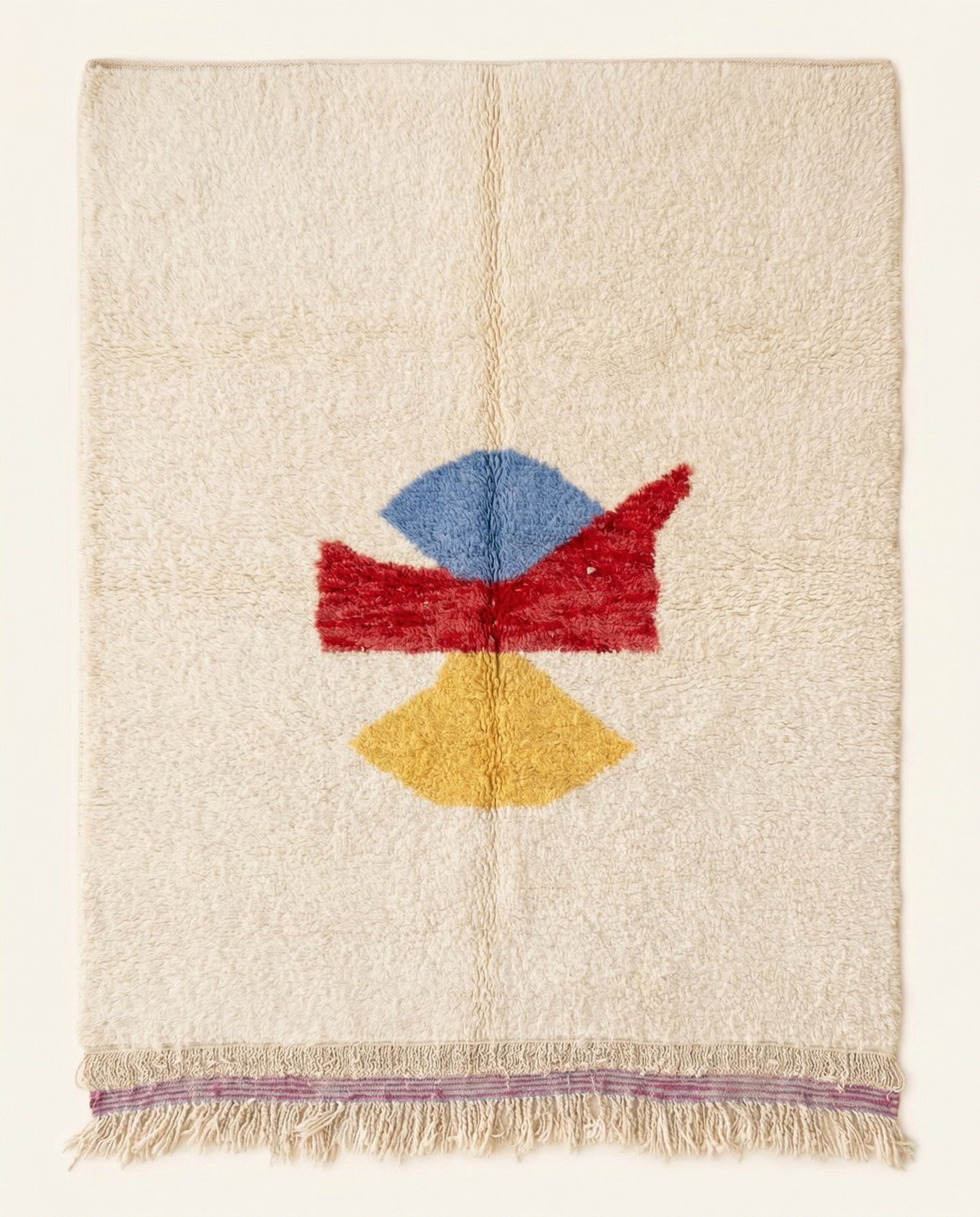 Plush ivory Azilal Moroccan rug with a bold abstract color block centerpiece in red, blue, and yellow, by NURA.