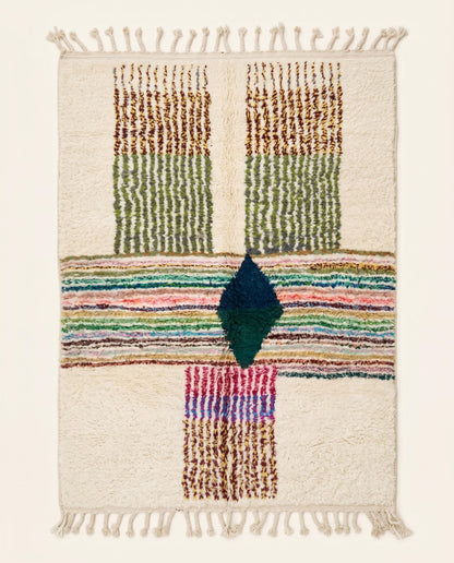 A plush Azilal Moroccan rug by NURA featuring a cream field with a central diamond, multi-colored stripes, and green blocks.