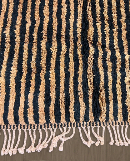 NABILA Beni Ourain black horizontal stripes Moroccan rug close-up of hand-tied fringe and kilim band detail, by NURA