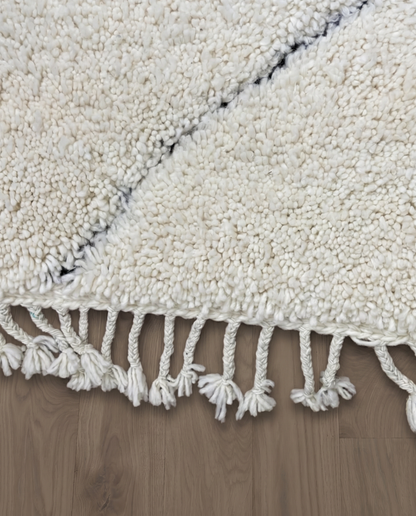 NASSIMA Beni Ourain ivory abstract diamond lattice Moroccan rug close-up of hand-tied fringe and kilim band detail, by NURA