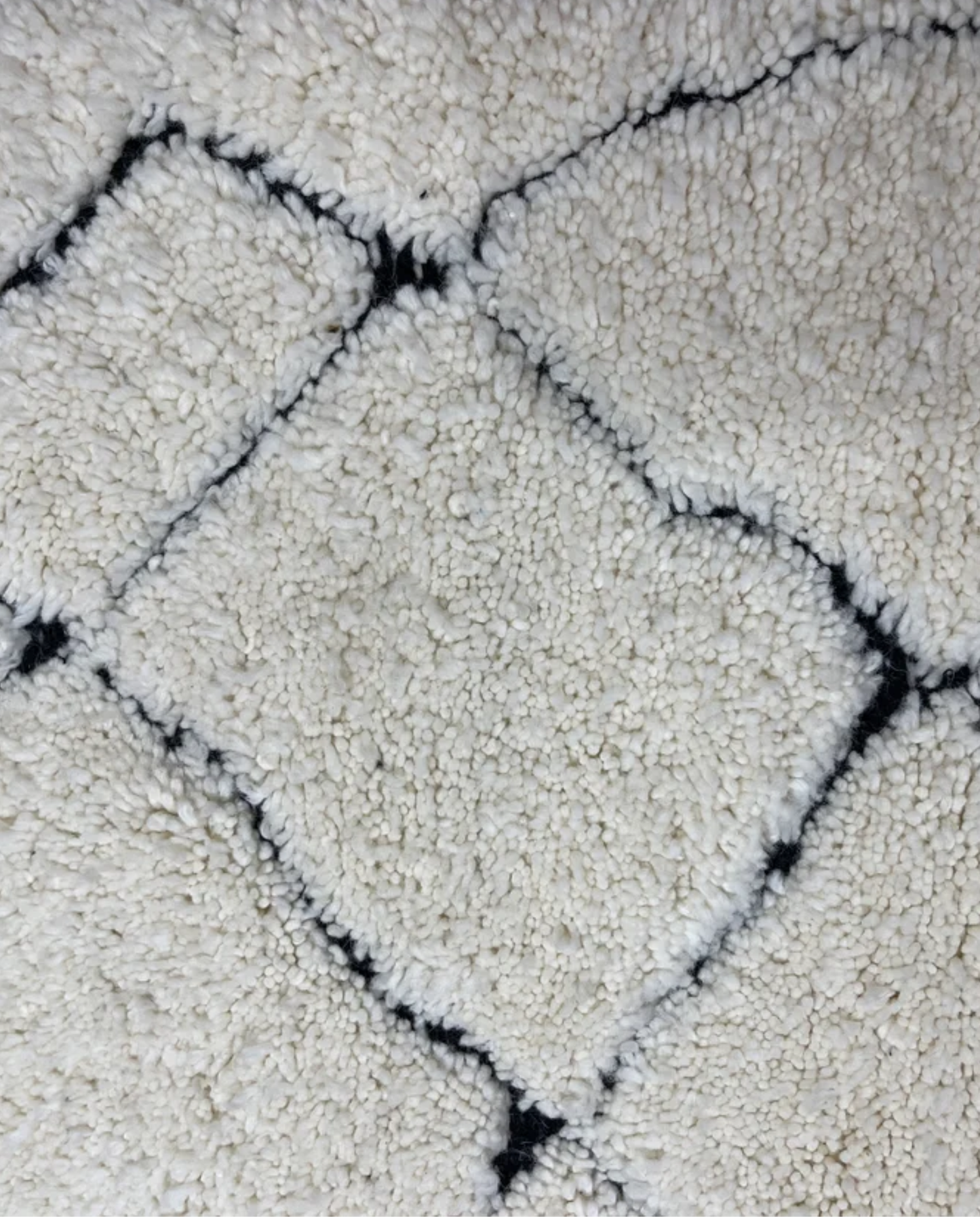 NASSIMA Beni Ourain ivory abstract diamond lattice Moroccan rug close-up showing hand-knotted wool texture and pile detail, by NURA
