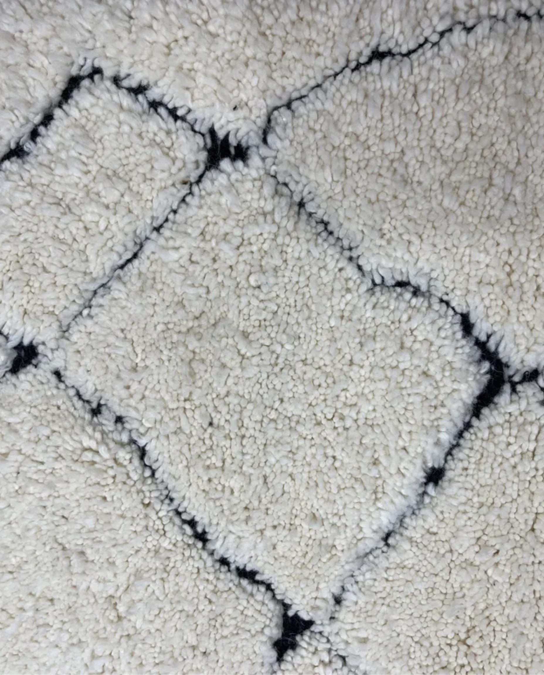 NASSIMA Beni Ourain ivory abstract diamond lattice Moroccan rug close-up showing hand-knotted wool texture and pile detail, by NURA