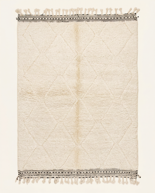 Plush cream Beni Ourain Moroccan rug with a sparse diamond lattice and flat-woven striped end bands, by NURA.