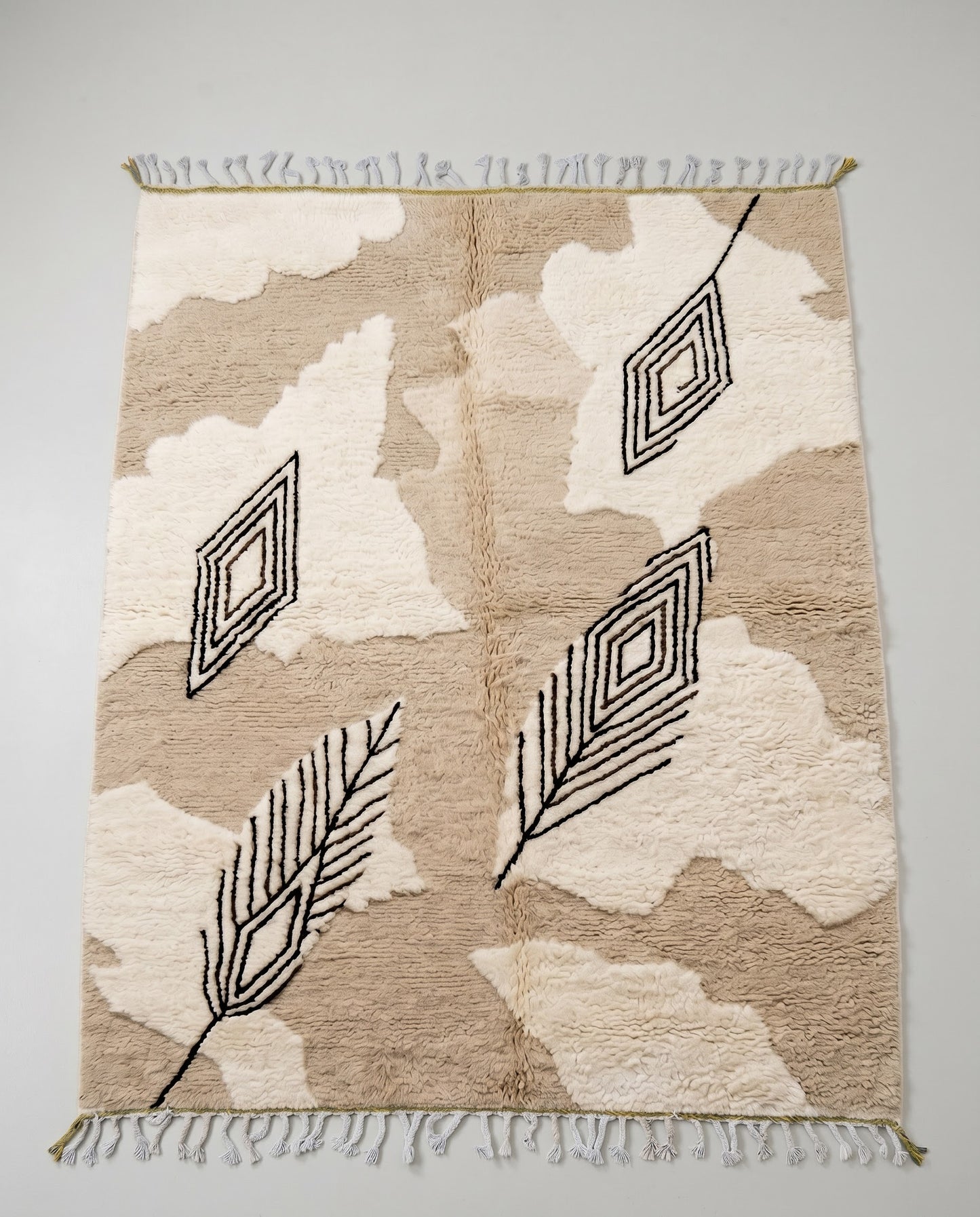 NOURIA Beni Ourain beige floating forms Moroccan rug displayed on a parquet wood floor, showing full fringe and edge detail, by NURA