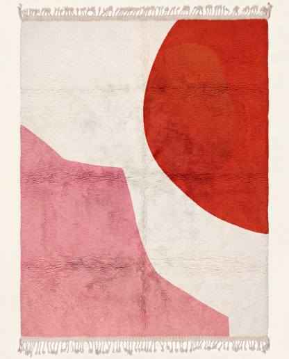 A contemporary Moroccan rug featuring a bold red circle and pink abstract shape on a plush cream wool field, by NURA.
