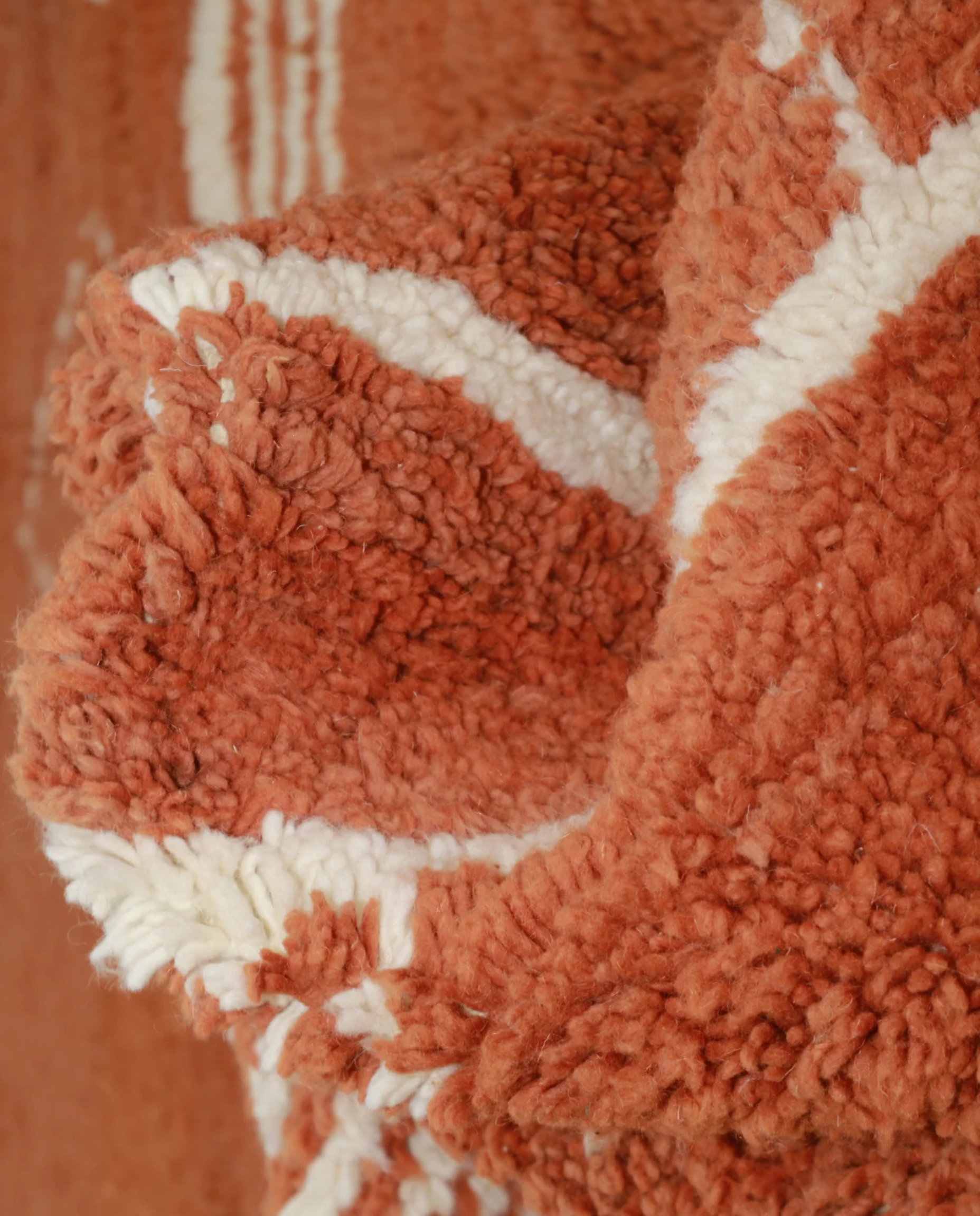 NUJA Boujad terracotta organic abstract Moroccan rug close-up showing hand-knotted wool texture and pile detail, by NURA