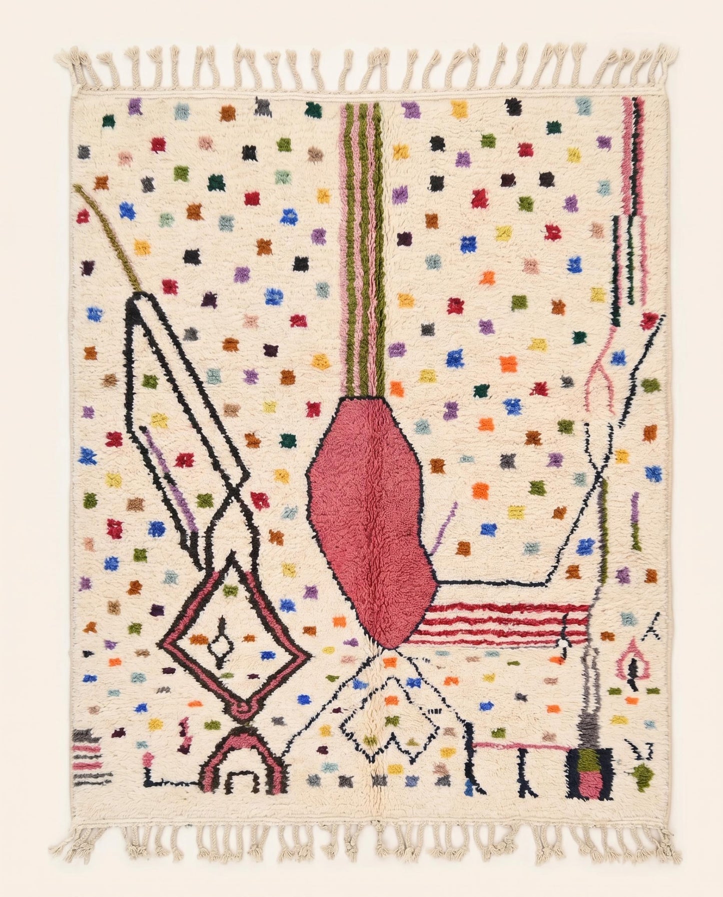 A vibrant Azilal Moroccan rug by NURA featuring a bold pink abstract form, dark lines, and colorful dots on a cream wool pile.