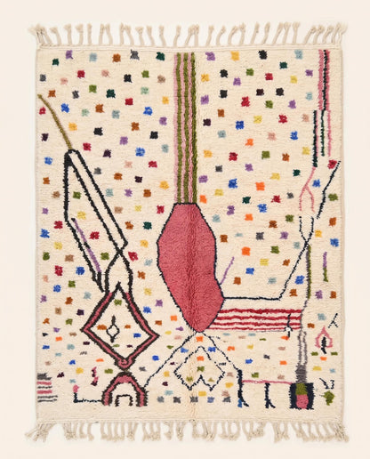A vibrant Azilal Moroccan rug by NURA featuring a bold pink abstract form, dark lines, and colorful dots on a cream wool pile.