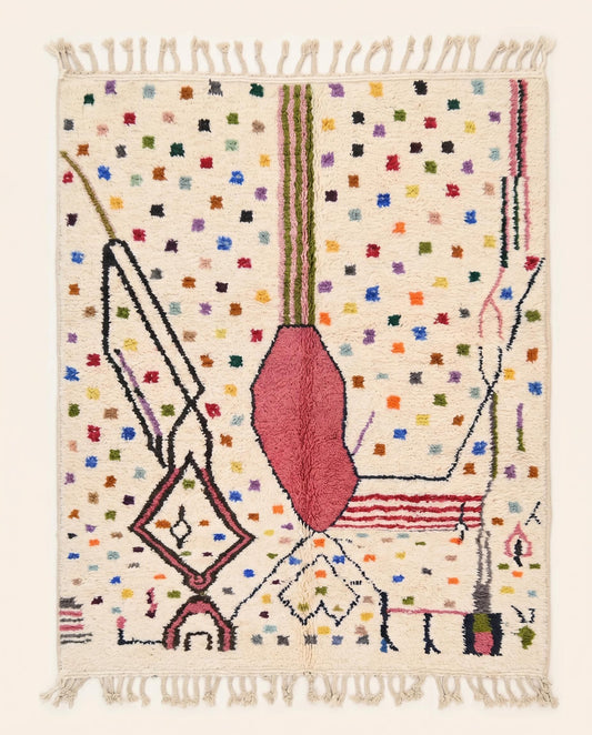 A vibrant Azilal Moroccan rug by NURA featuring a bold pink abstract form, dark lines, and colorful dots on a cream wool pile.