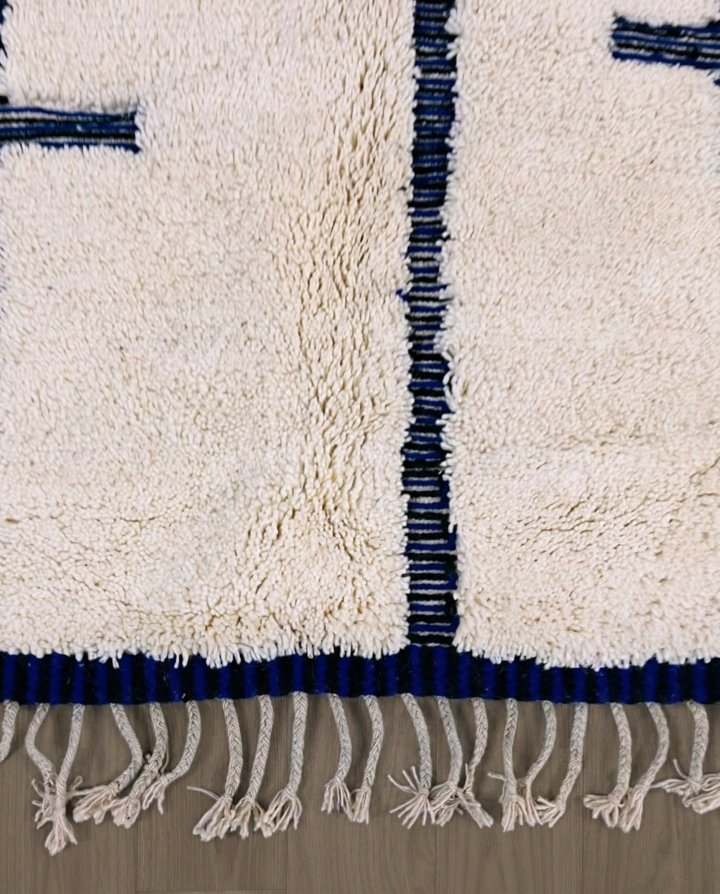 RABAB Beni Ourain cream abstract linear field Moroccan rug close-up of hand-tied fringe and kilim band detail, by NURA