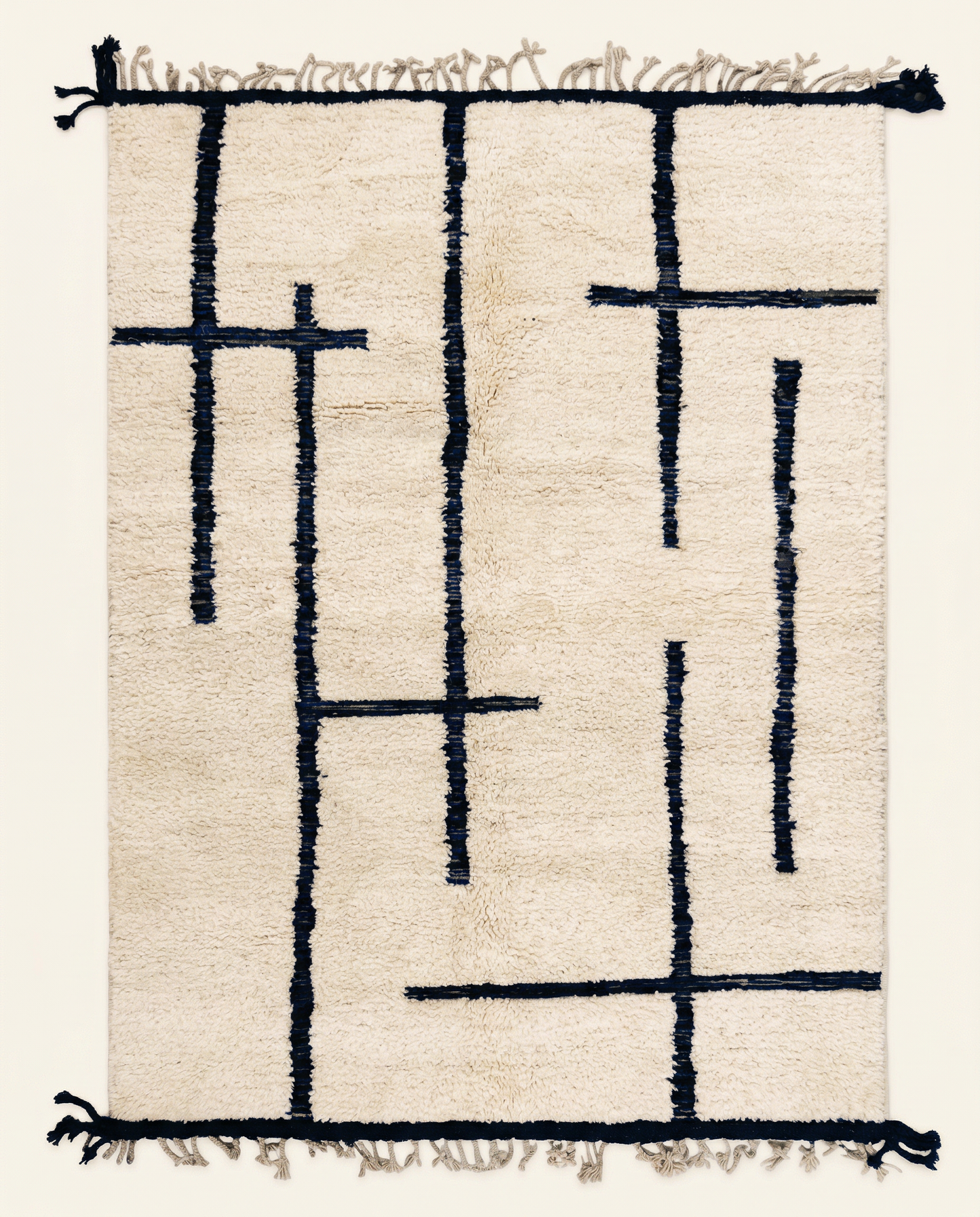 Plush cream Beni Ourain Moroccan rug with bold asymmetrical navy blue intersecting lines and a high pile, by NURA.