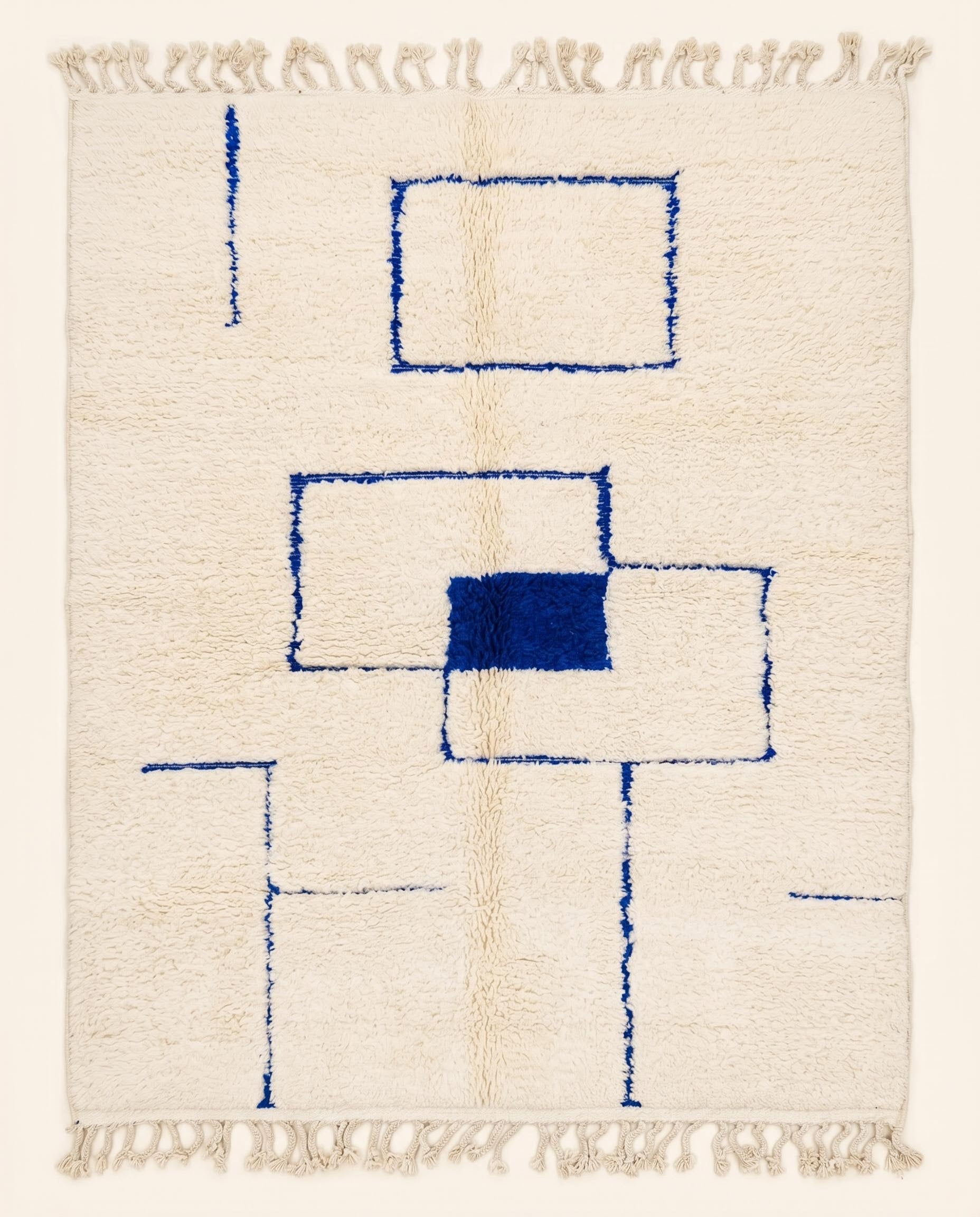 A plush cream Azilal Moroccan rug featuring bold blue geometric squares and crisp line work, crafted from soft wool by NURA.