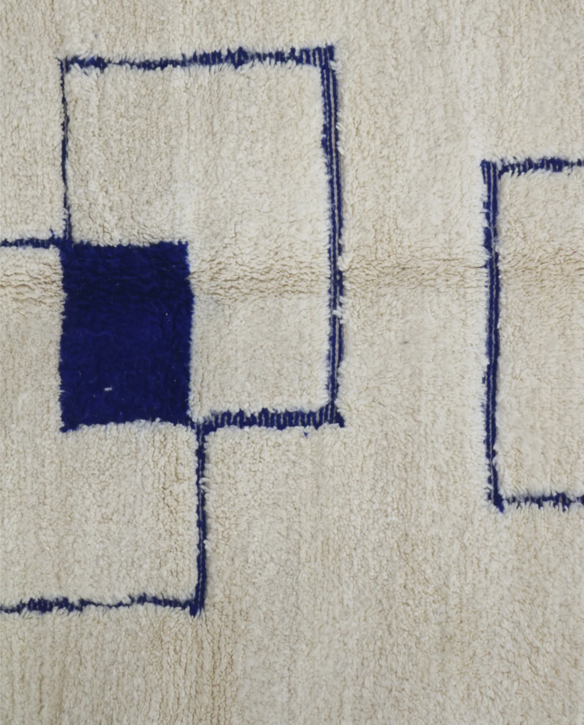 RADNA Azilal cream floating forms Moroccan rug close-up showing hand-knotted wool texture and pile detail, by NURA