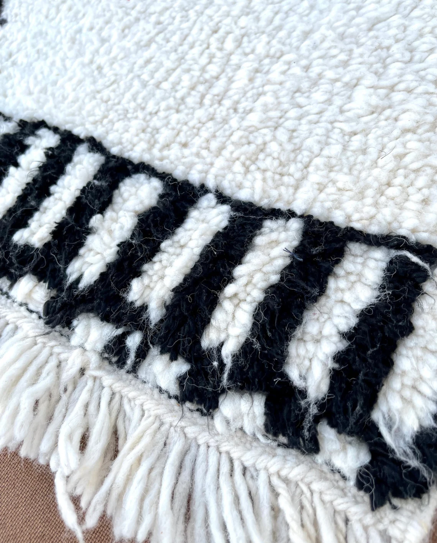 RADWA Azilal ivory scattered abstract motifs Moroccan rug close-up of hand-tied fringe and kilim band detail, by NURA